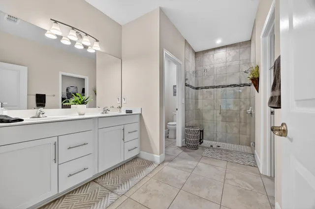 a bathroom with a double vanity sink mirror and shower