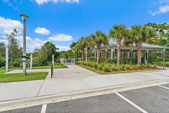 a view of yellow house with a big yard and plants