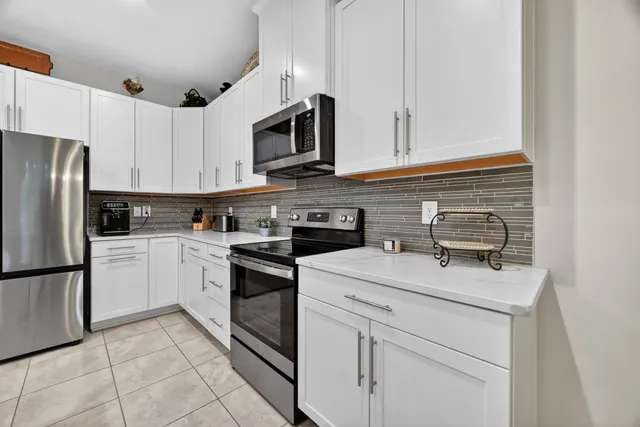 a kitchen with white cabinets stainless steel appliances and sink
