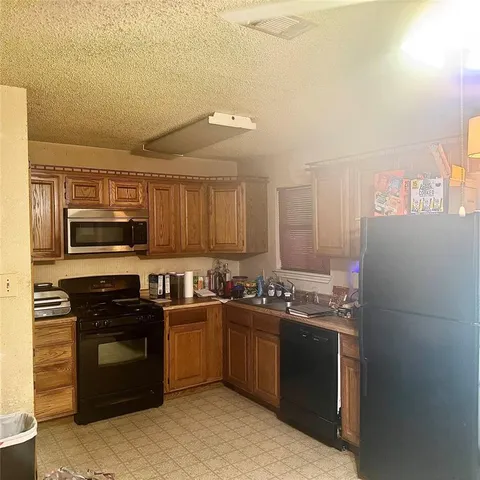 a kitchen with stainless steel appliances a stove sink and refrigerator