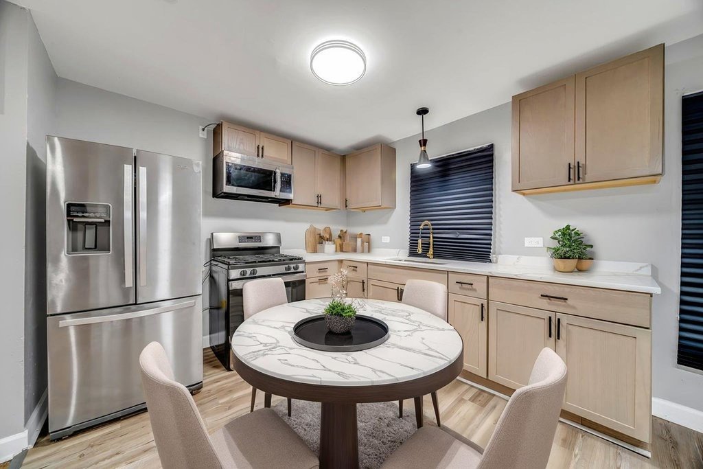 15417 Cherry Lane Markham, IL 60428 - Photo 7 of 24 a kitchen with stainless steel appliances granite countertop a stove a sink a refrigerator a dining table and chairs