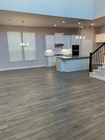 a view of kitchen with wooden floor and electronic appliances