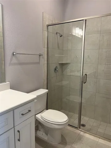 a bathroom with a shower a toilet and a sink