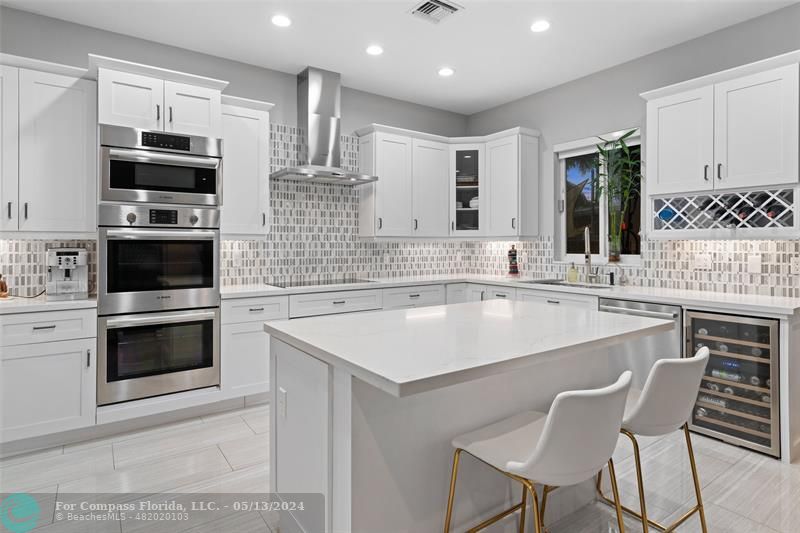a kitchen with stainless steel appliances kitchen island granite countertop a sink and stove top oven