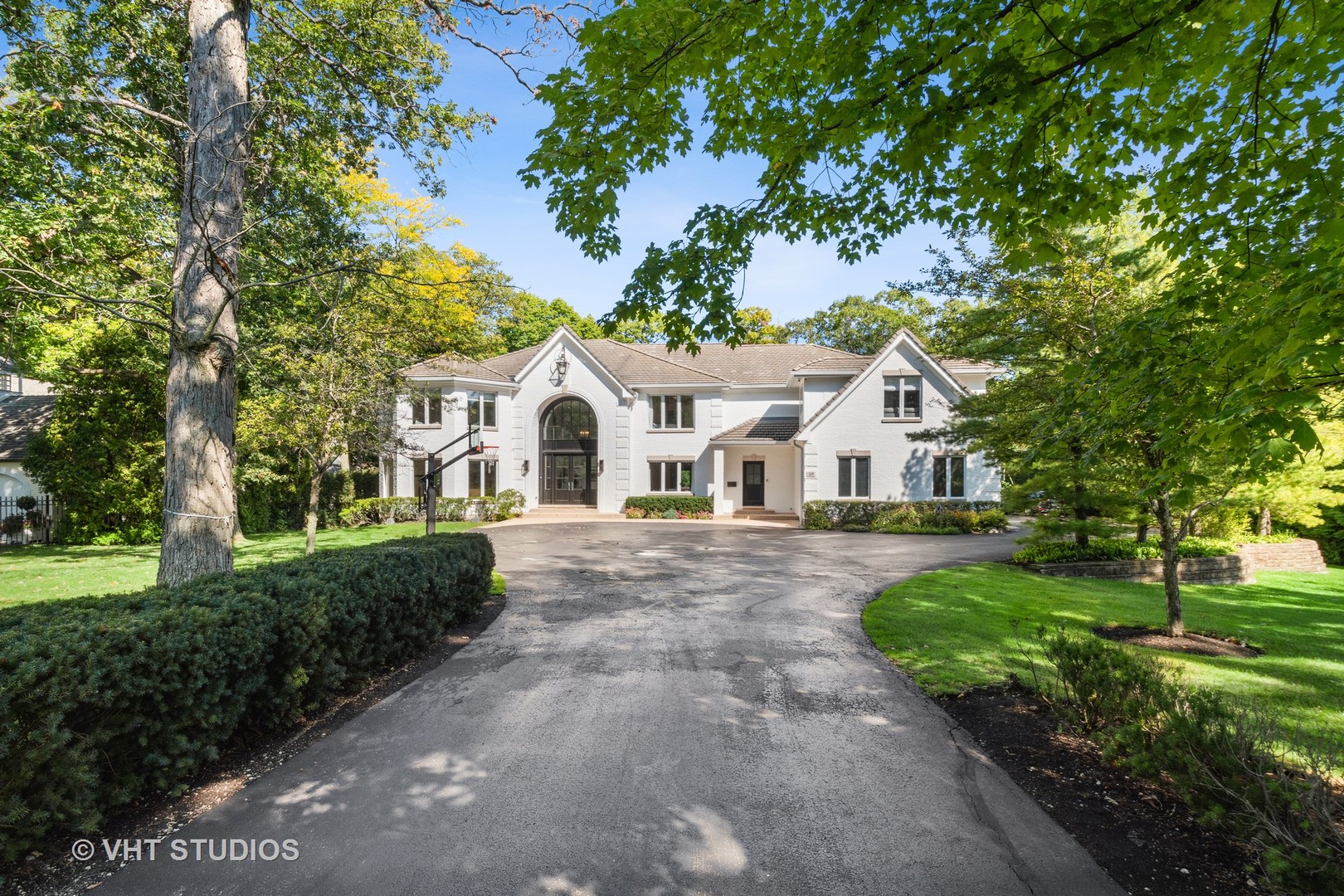 a view of a white house with a yard and potted plants