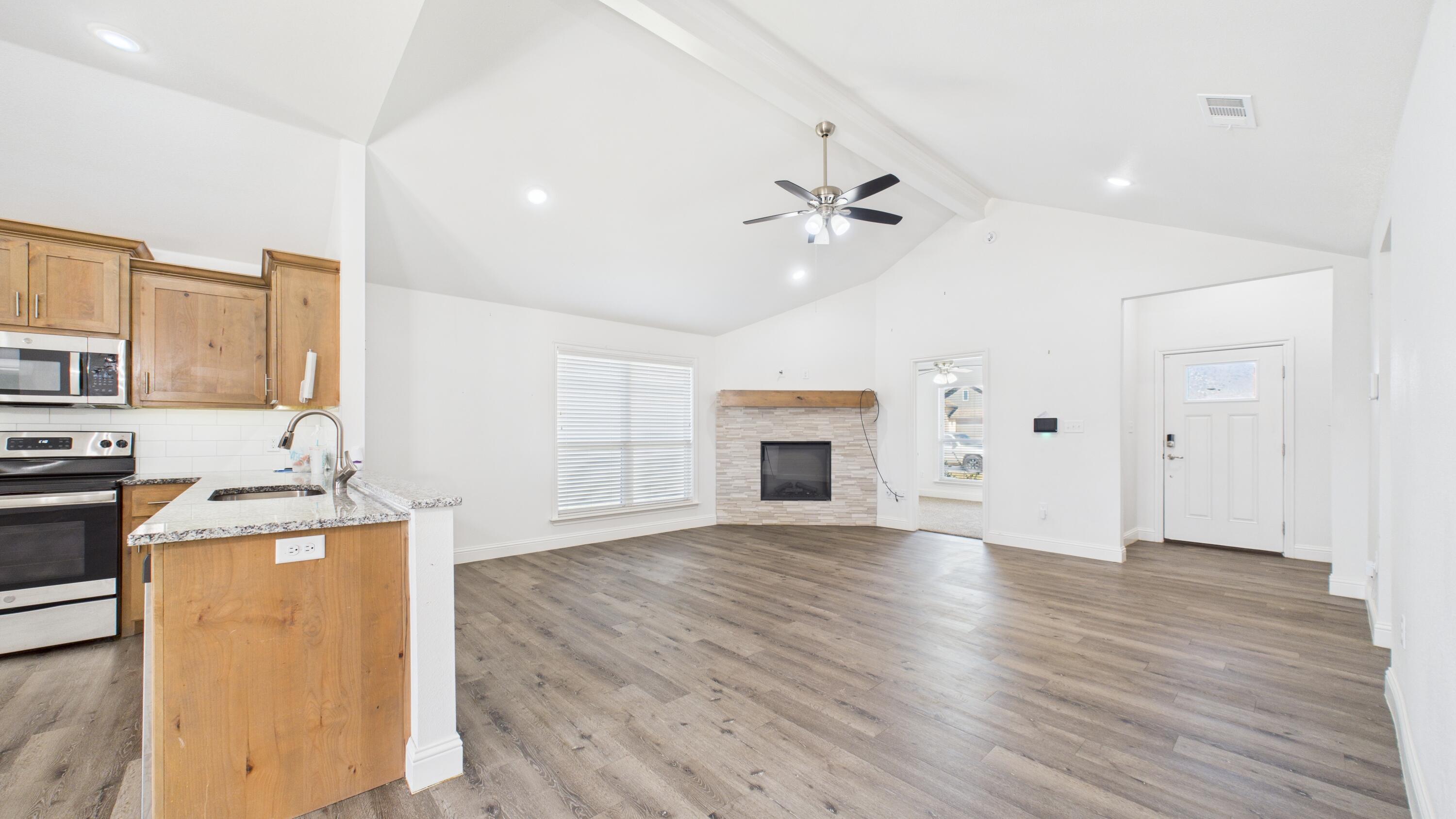 7107 23rd Street Lubbock, TX 79407 - Photo 12 of 49 a view of a kitchen with a sink a fireplace and a window