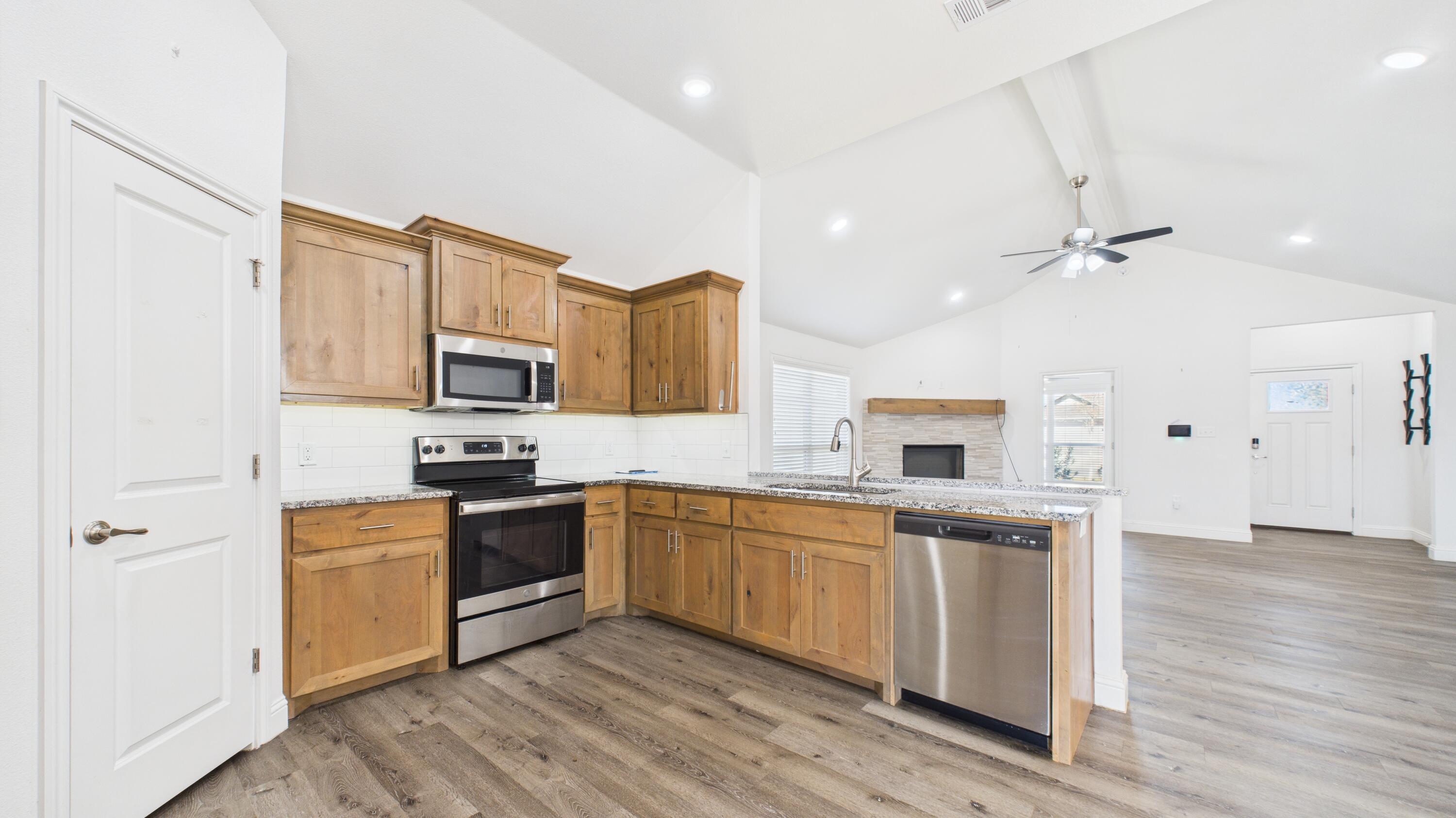7107 23rd Street Lubbock, TX 79407 - Photo 23 of 49 a kitchen with stainless steel appliances granite countertop a sink a stove top oven a counter space and cabinets