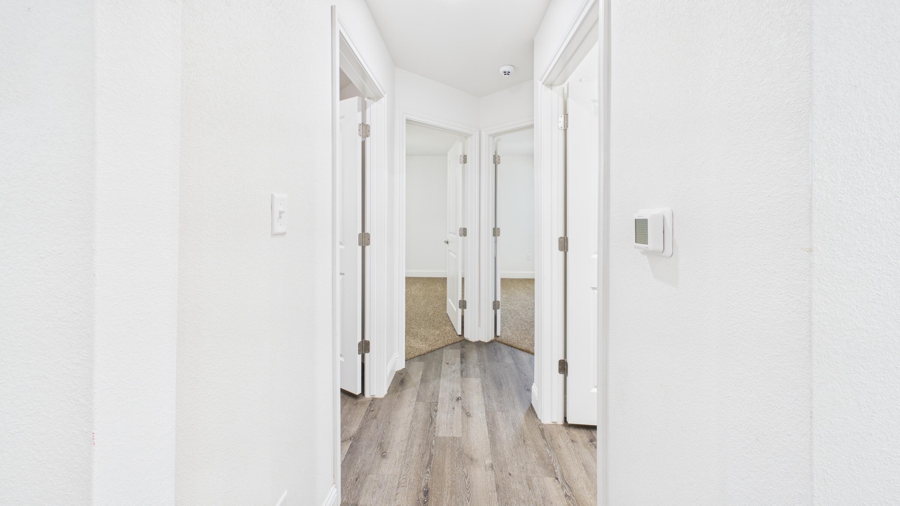 7107 23rd Street Lubbock, TX 79407 - Photo 27 of 49 a view of a hallway with wooden floor and a bathroom