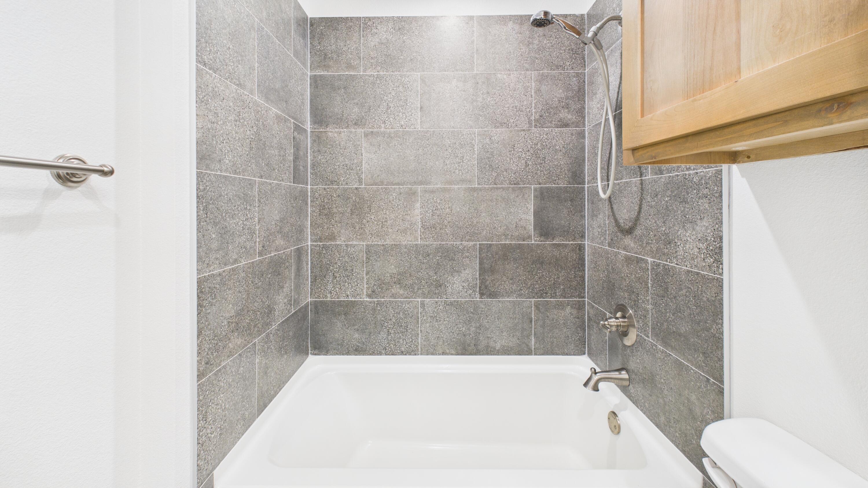 7107 23rd Street Lubbock, TX 79407 - Photo 30 of 49 a bathroom with a bathtub and a shower