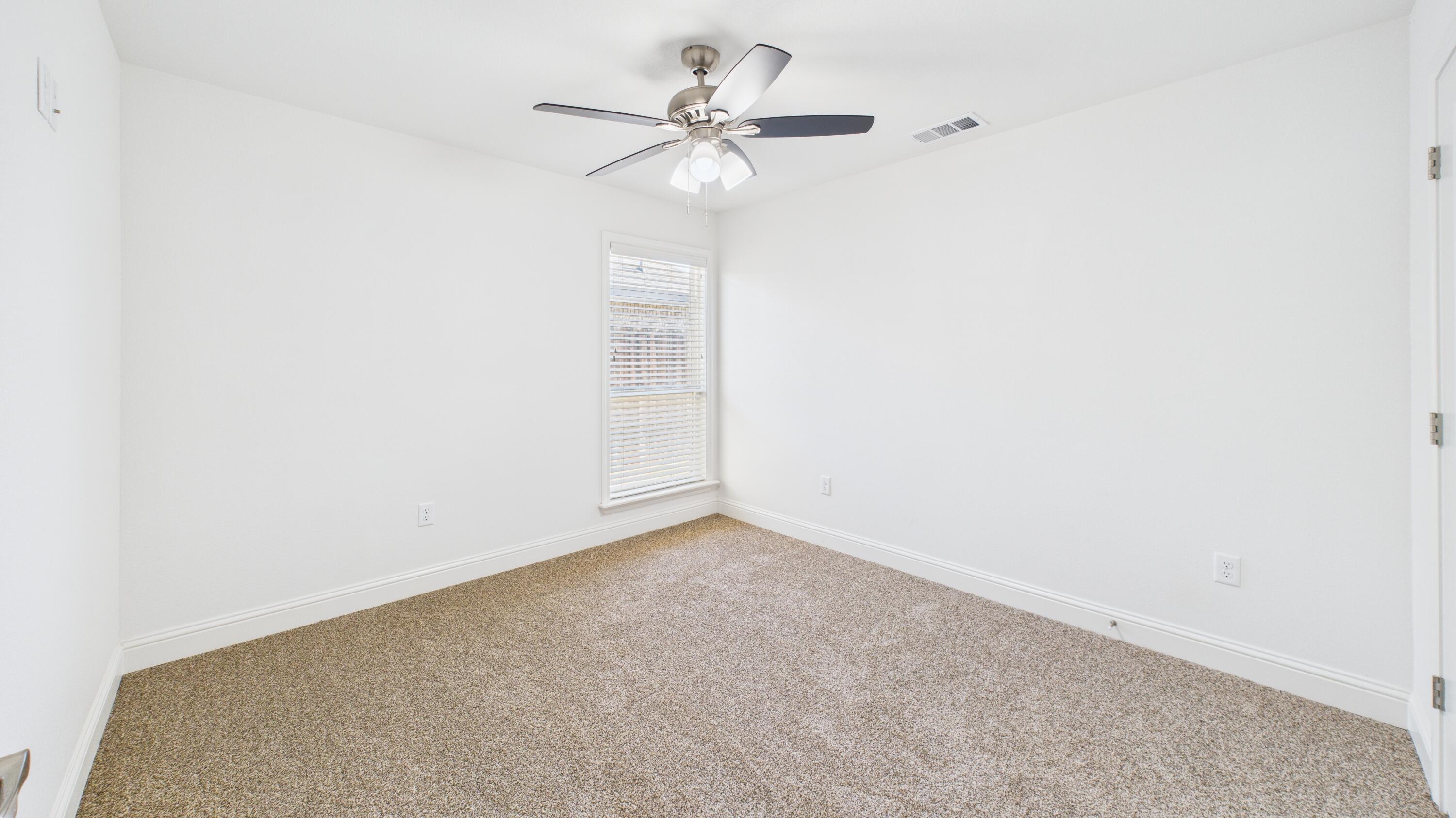 7107 23rd Street Lubbock, TX 79407 - Photo 35 of 49 an empty room with a window and a ceiling fan