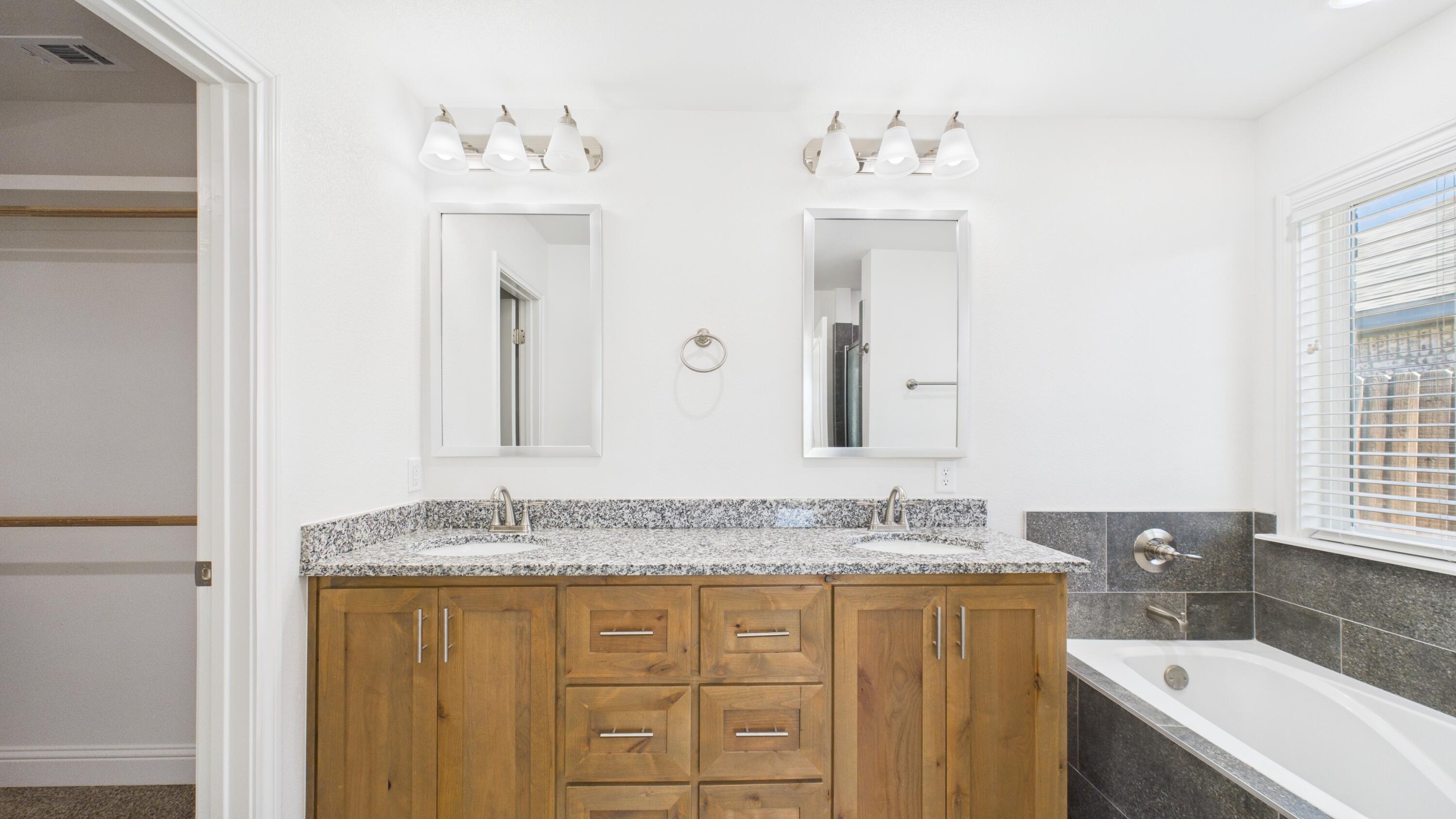 7107 23rd Street Lubbock, TX 79407 - Photo 41 of 49 a bathroom with a granite countertop sink mirror and