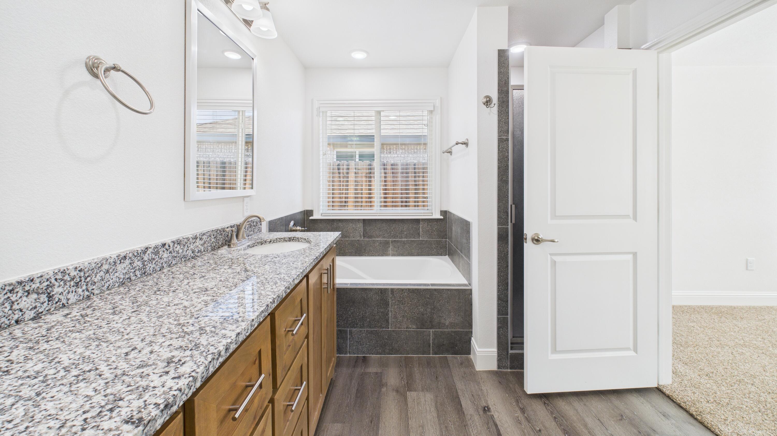 7107 23rd Street Lubbock, TX 79407 - Photo 42 of 49 a bathroom with a granite countertop sink and a mirror