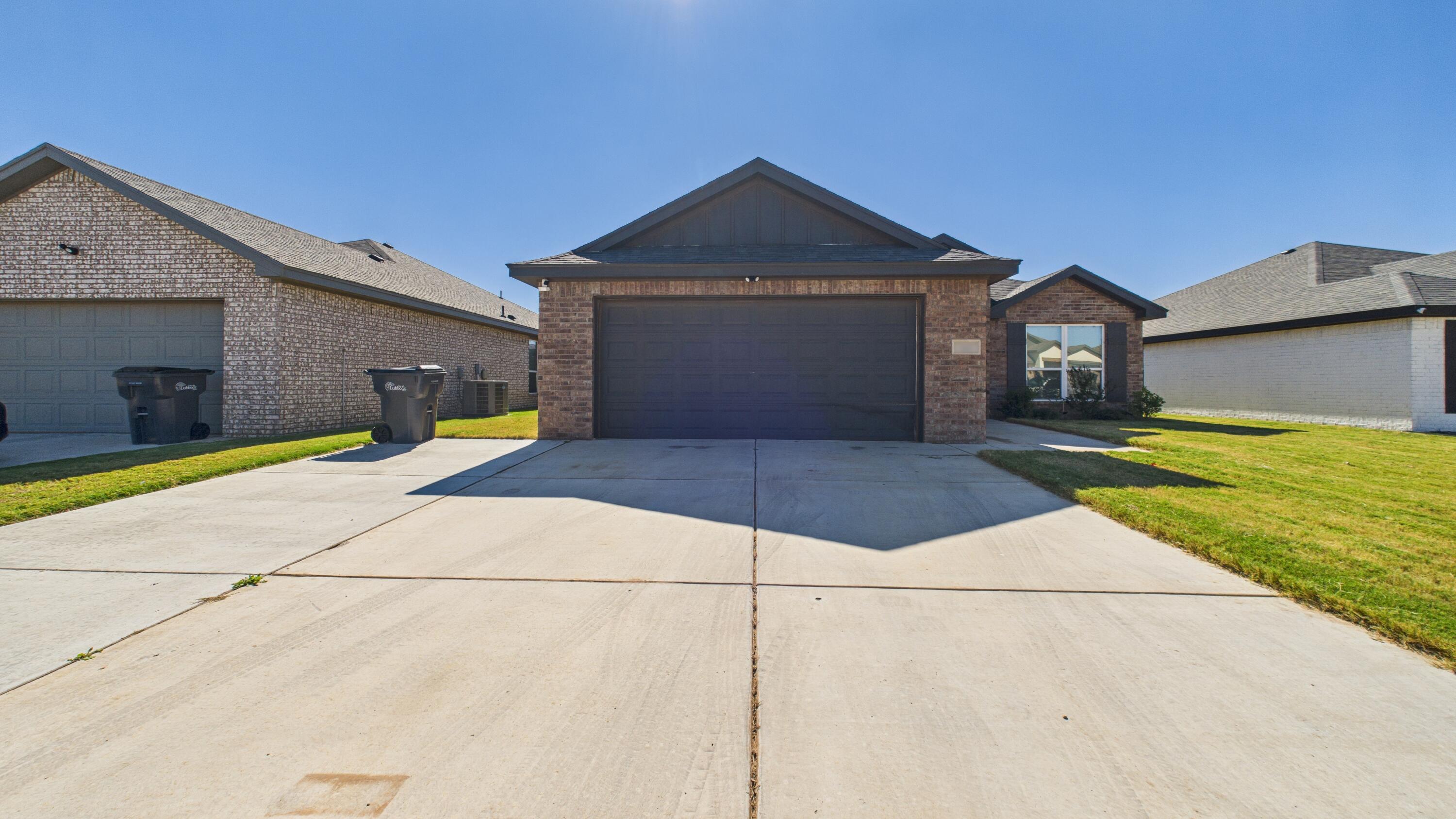 7107 23rd Street Lubbock, TX 79407 - Photo 7 of 49 a front view of a house with a yard and garage