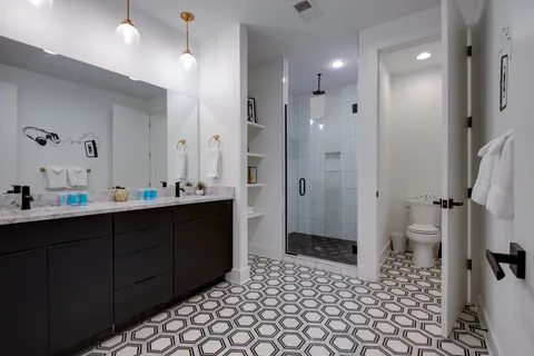 a bathroom with a sink a toilet and shower