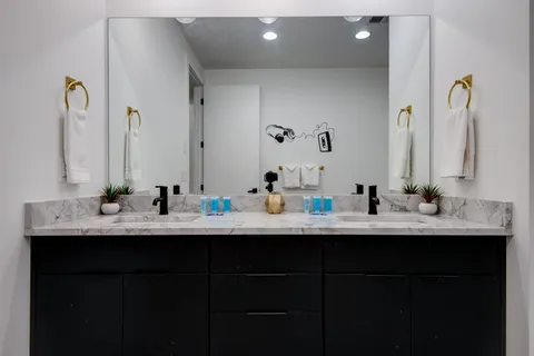 a bathroom with double sink and a mirror