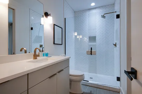 a bathroom with a sink a toilet and shower