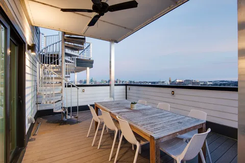 a balcony with table and chairs