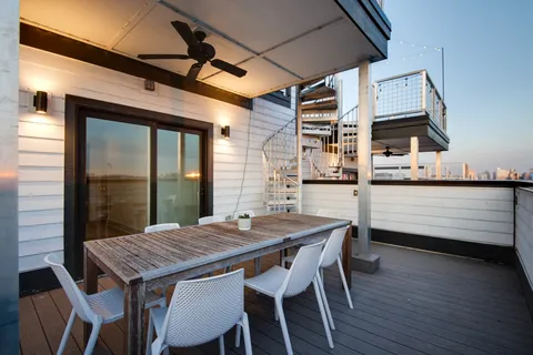 a dinning table and chairs in front of a house