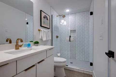 a bathroom with a sink a toilet and shower