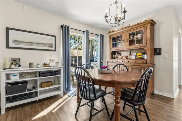 a dining room with furniture a chandelier and wooden floor