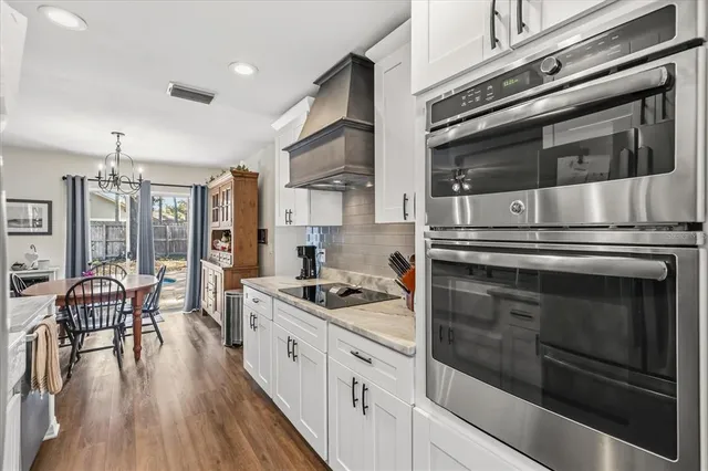 a kitchen with stainless steel appliances granite countertop a stove and a wooden cabinets