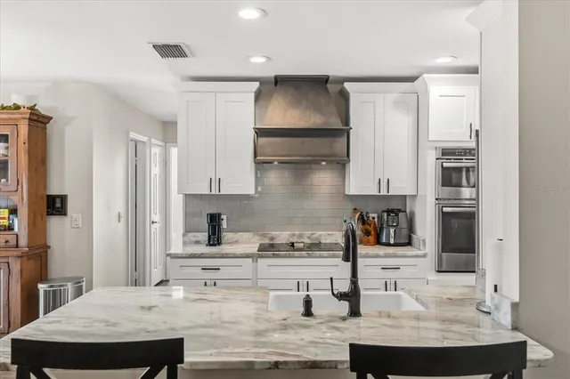 a kitchen with stainless steel appliances granite countertop a sink refrigerator and cabinets