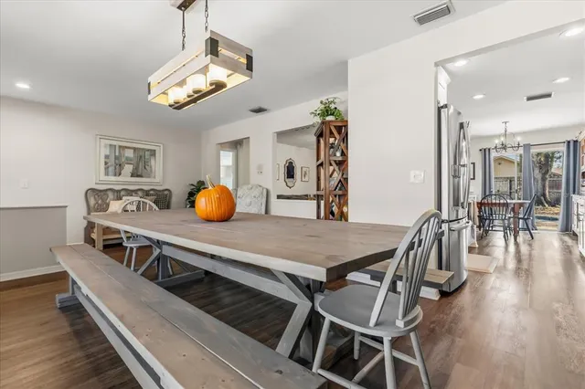 a kitchen with a dining table chairs and chandelier