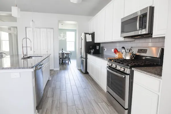 a kitchen with granite countertop wooden cabinets stainless steel appliances and a counter space