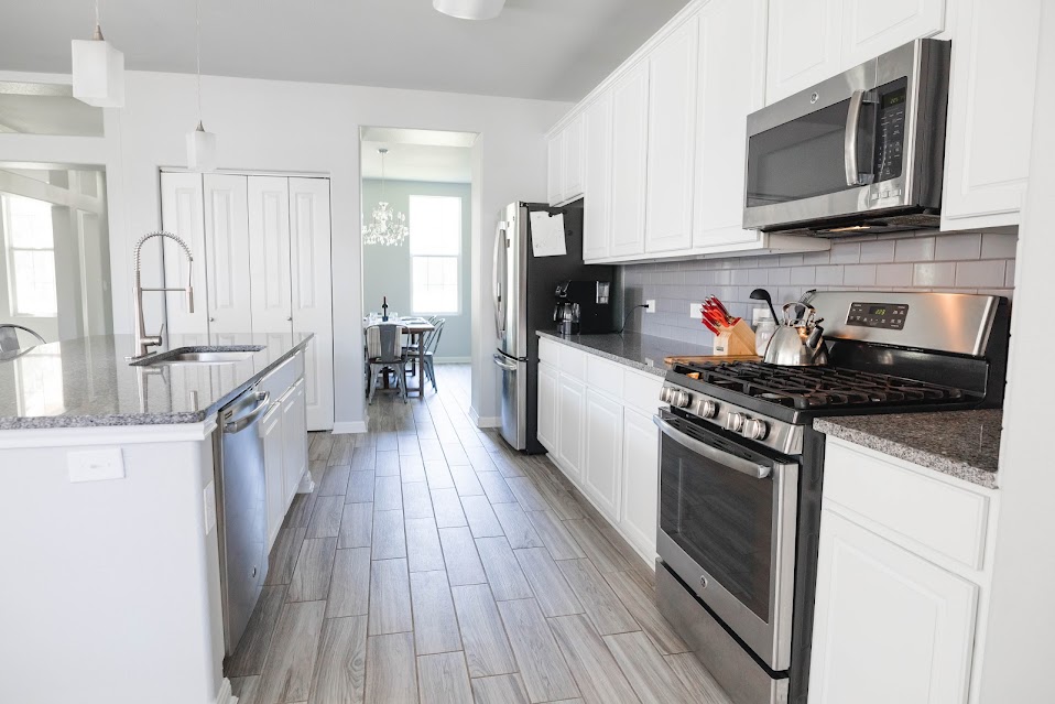 411 Wetzel Kyle, TX 78640 - Photo 12 of 28 a kitchen with granite countertop wooden cabinets stainless steel appliances and a counter space