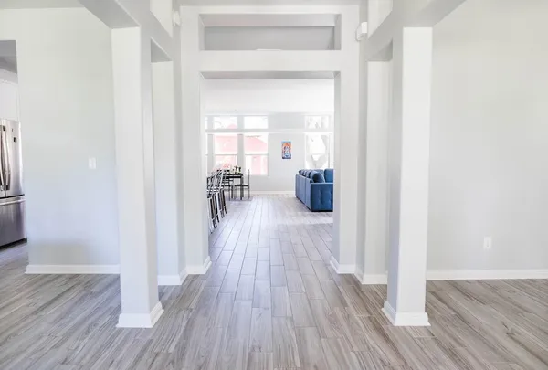 a view of a hallway with wooden floor and furniture