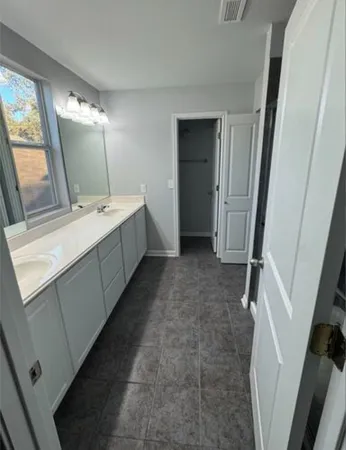 a bathroom with a double vanity sink and mirror with bathtub