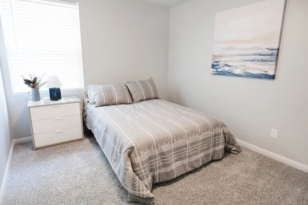 a bed room with a bed and a painting on the wall