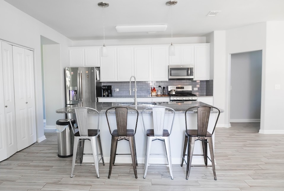 411 Wetzel Kyle, TX 78640 - Photo 10 of 28 a kitchen with stainless steel appliances kitchen island granite countertop a dining table chairs and a refrigerator