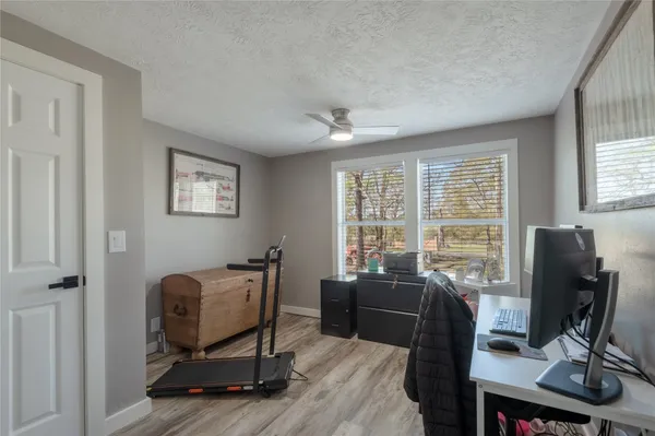 a view of a workspace with furniture and a window