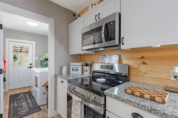 a kitchen with stainless steel appliances granite countertop a stove and a microwave