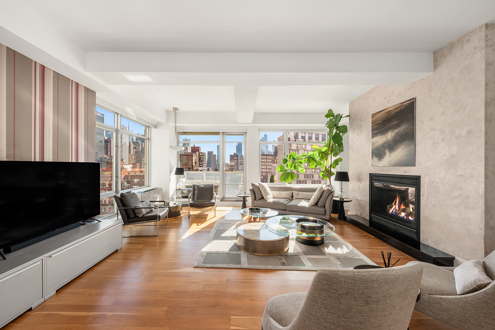 426 West 58th Street, Unit PH3 Manhattan, NY 10019 - Photo 1 of 22 a living room with furniture a flat screen tv and a fireplace