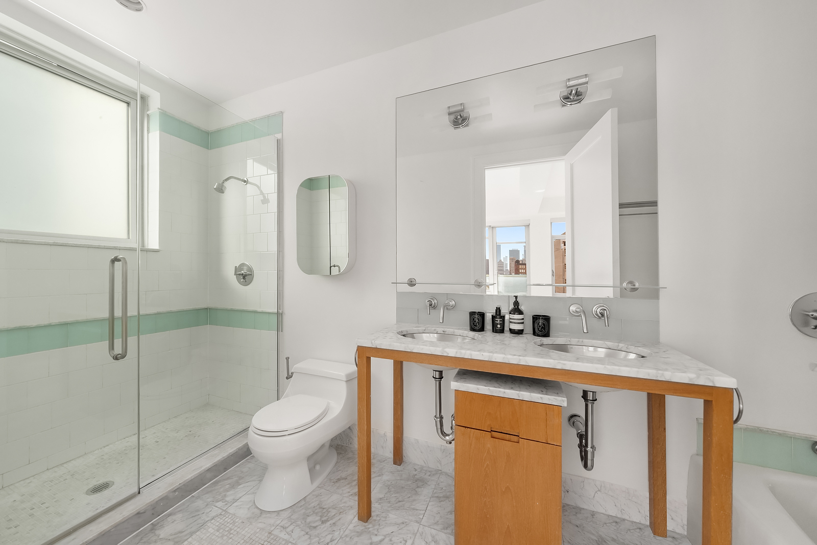 426 West 58th Street, Unit PH3 Manhattan, NY 10019 - Photo 15 of 22 a bathroom with a granite countertop sink toilet a mirror and shower