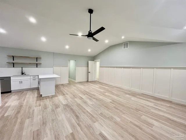 a view of a kitchen with a sink and wooden floor