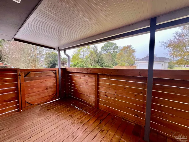 a view of an empty room with window and chandelier fan