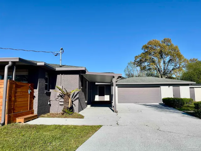 a view of house with backyard and outdoor seating