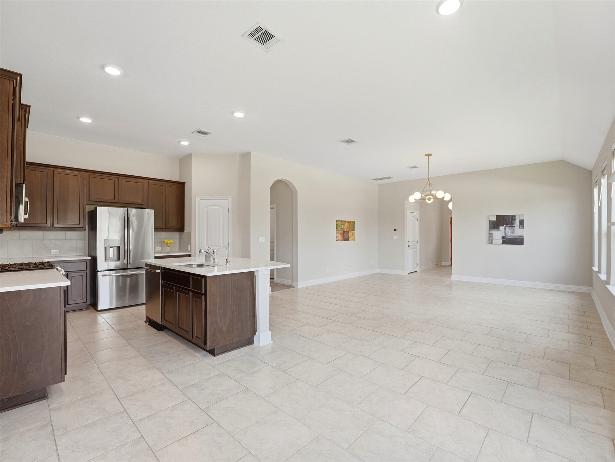 2132 Ringstaff Road Leander, TX 78641 - Photo 13 of 39 An open-concept design connects a well-appointed kitchen with an airy living space, illuminated by recessed lighting and natural light.