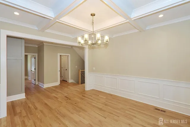 a view of a livingroom with a chandelier fan and kitchen view