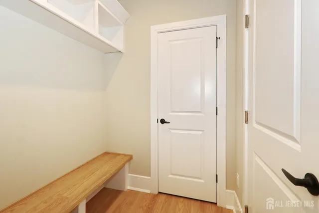 a view of a hallway with wooden floor and closet
