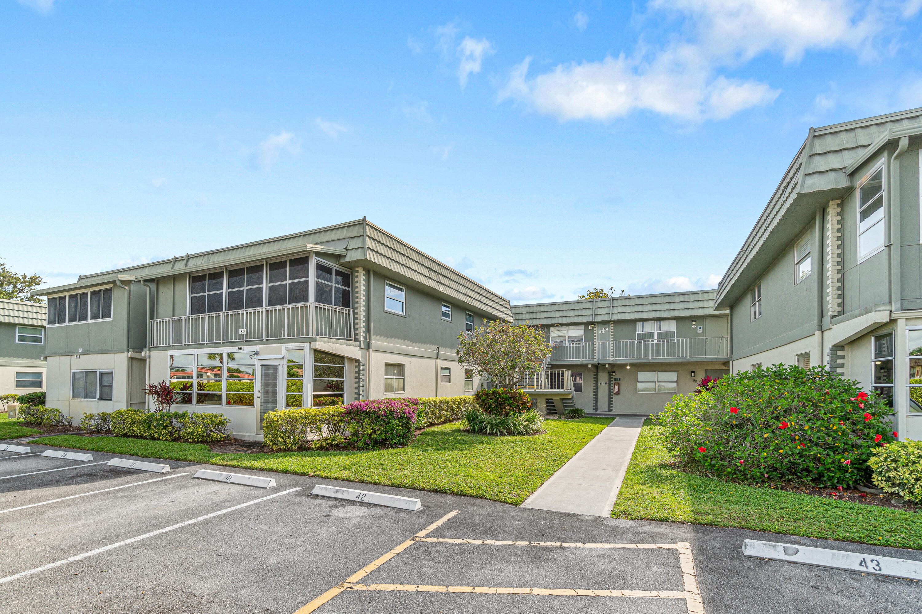 80 Flanders B Delray Beach, FL 33484 - Photo 23 of 26 a front view of a building with garden