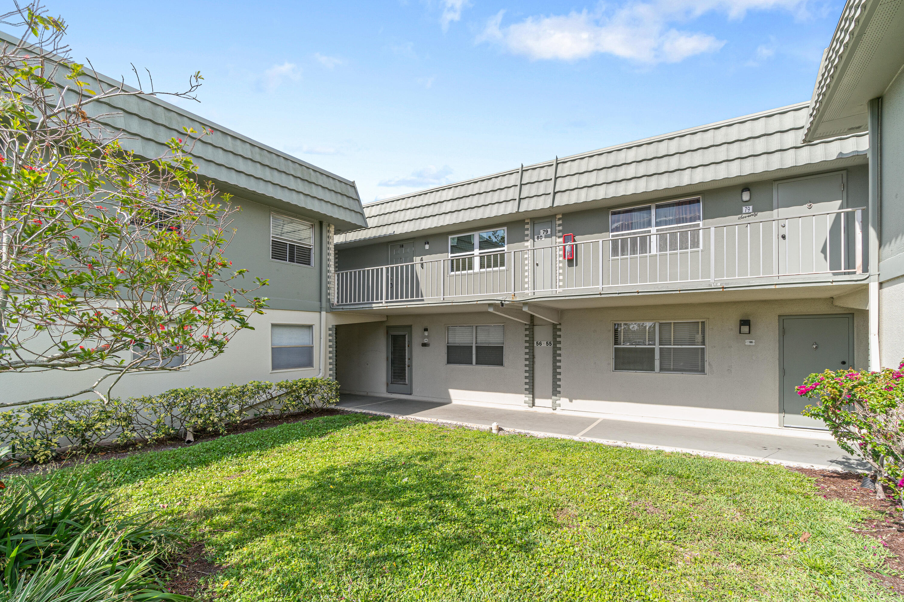 80 Flanders B Delray Beach, FL 33484 - Photo 24 of 26 a front view of a house with a yard