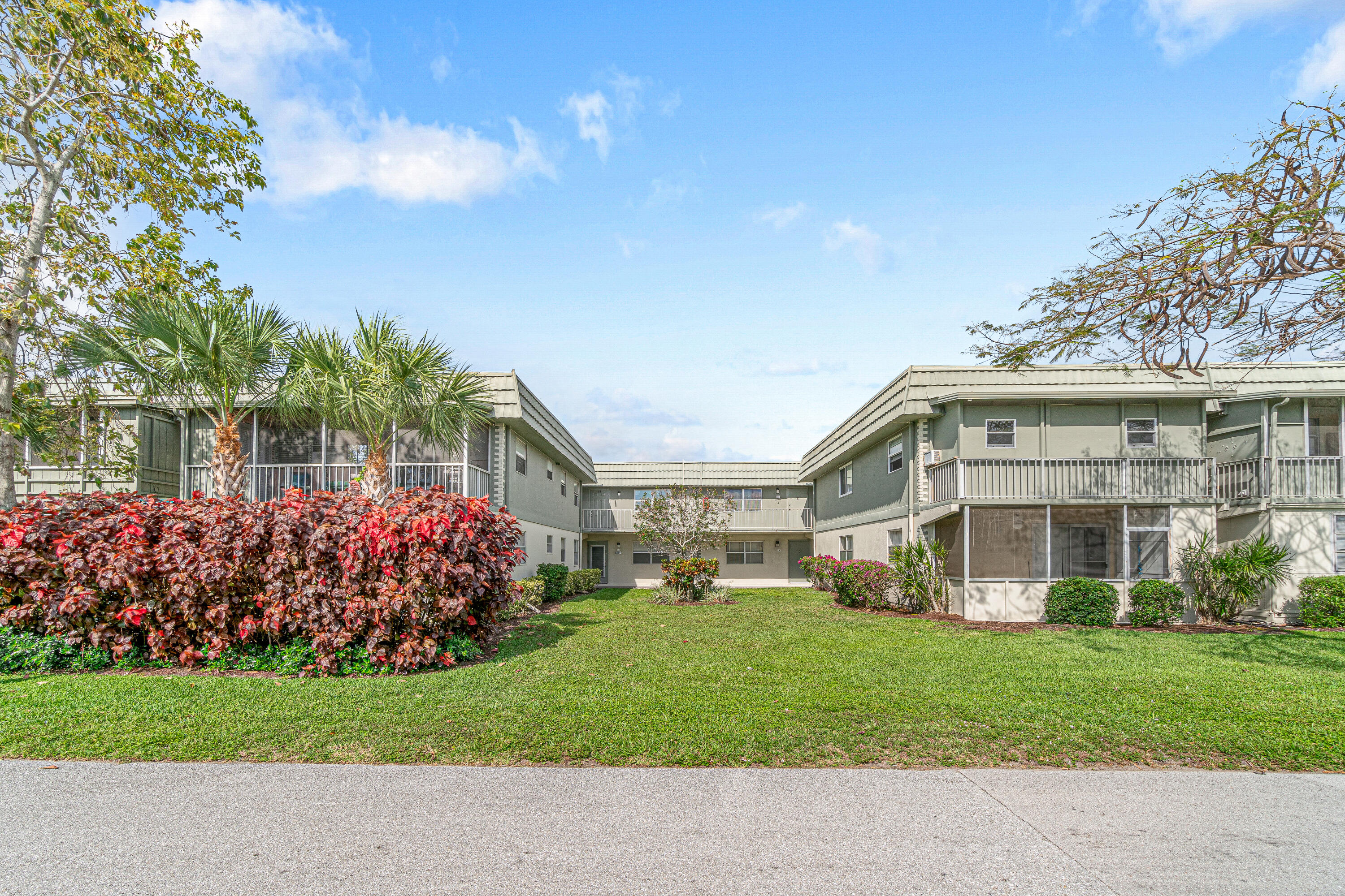 80 Flanders B Delray Beach, FL 33484 - Photo 25 of 26 a front view of a house with a garden and trees