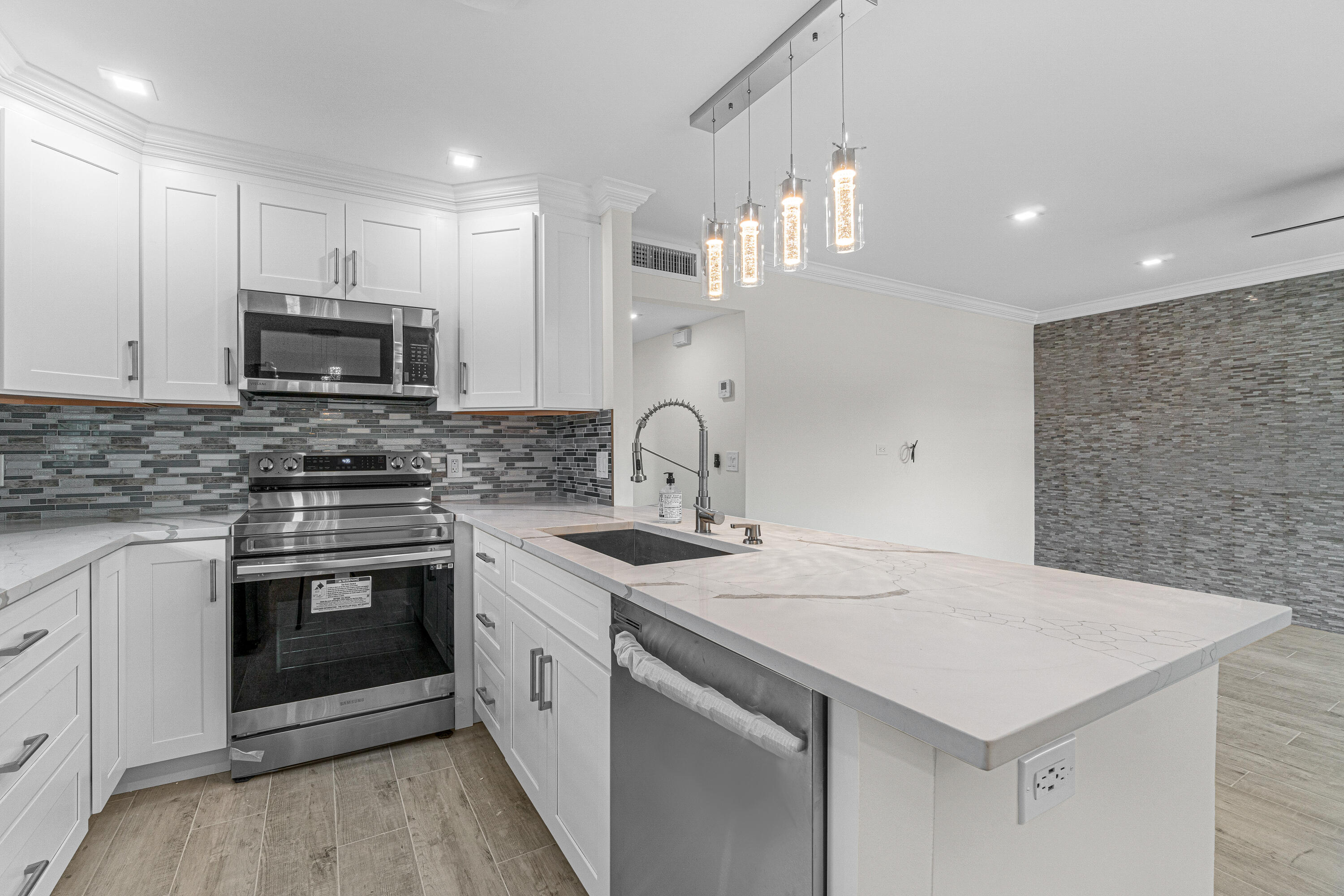 80 Flanders B Delray Beach, FL 33484 - Photo 4 of 26 a kitchen with a sink cabinets and stainless steel appliances