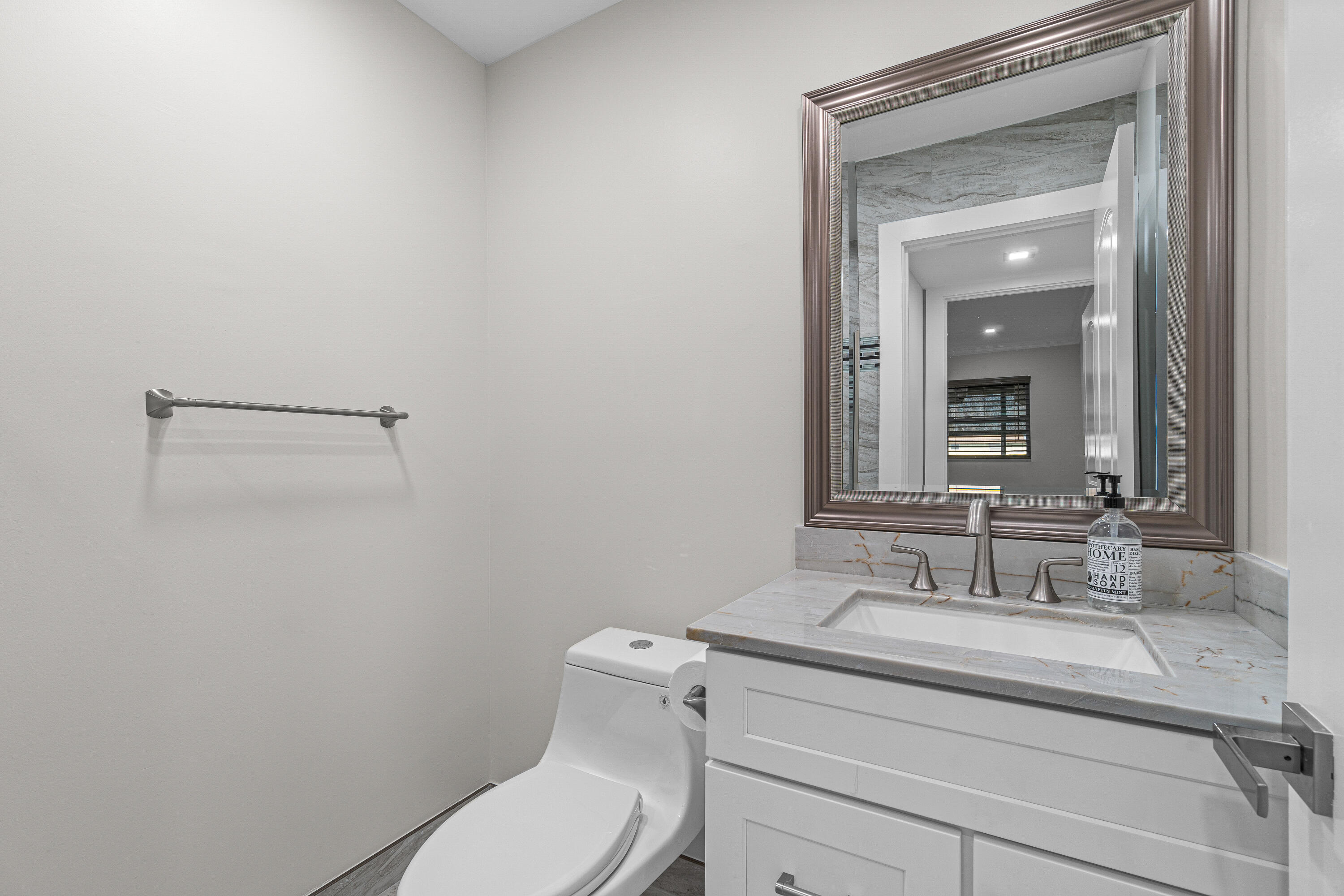 80 Flanders B Delray Beach, FL 33484 - Photo 7 of 26 a bathroom with a granite countertop toilet sink and mirror