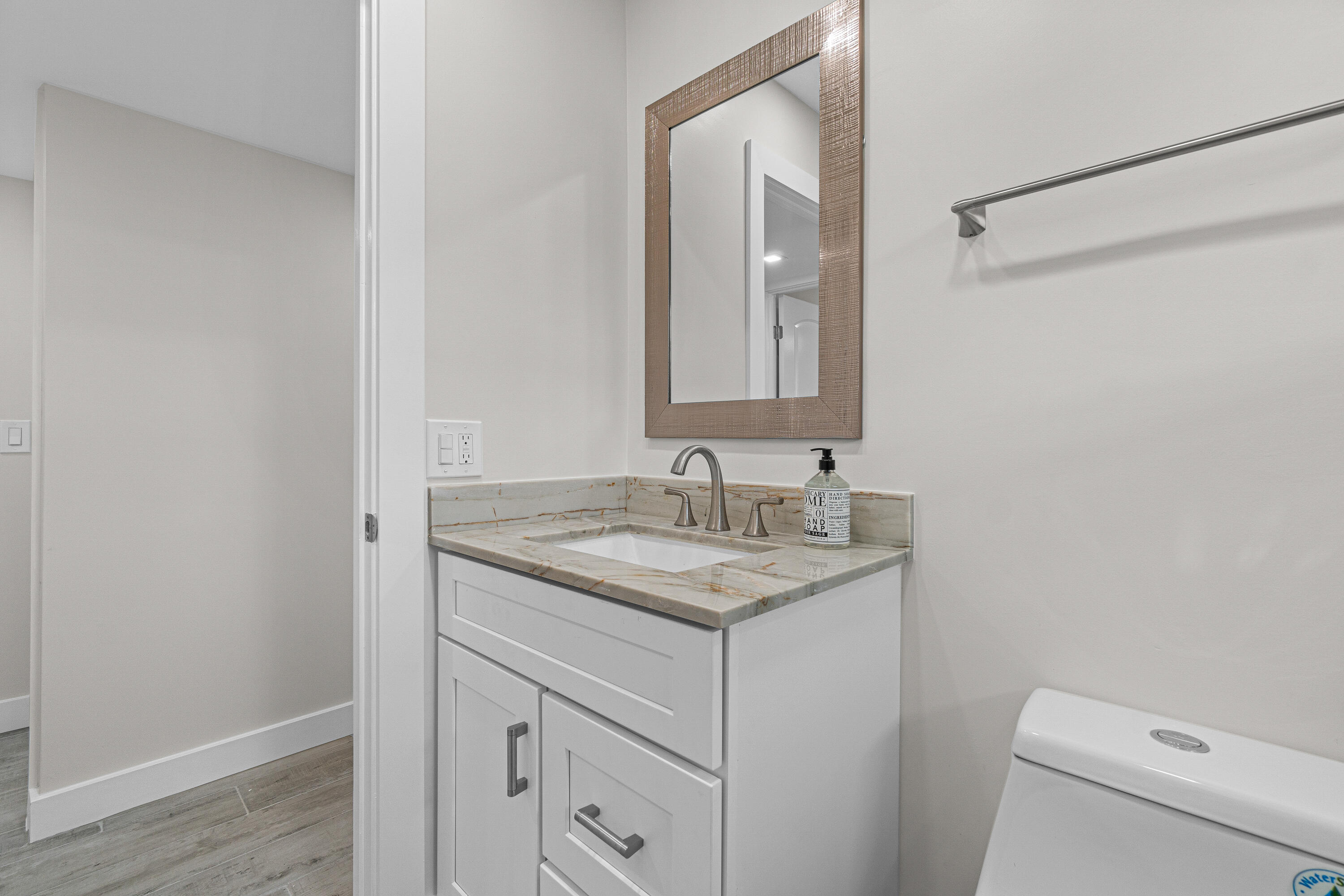 80 Flanders B Delray Beach, FL 33484 - Photo 10 of 26 a bathroom with a granite countertop sink a toilet and a mirror