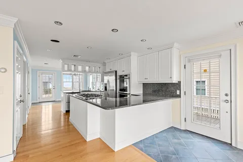 a large kitchen with stainless steel appliances granite countertop a stove and a refrigerator